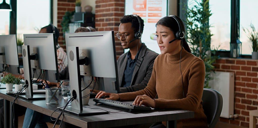 Team members on headsets taking calls at their desks